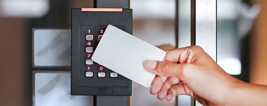 A person swiping their access card into a card access system in Tampa to enter into a building