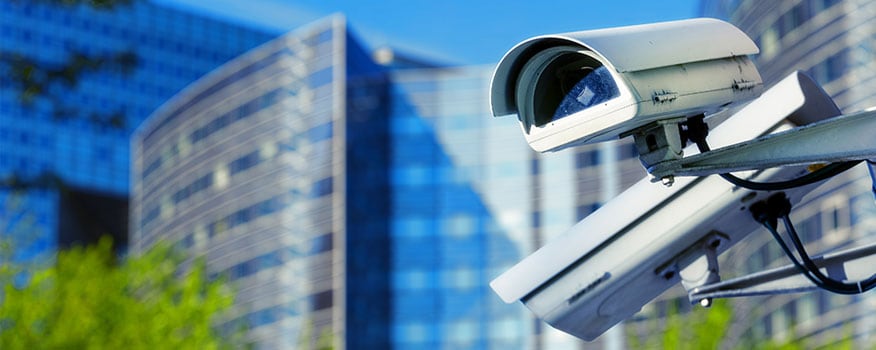 Two white commercial surveillance camera systems in Tampa outside large commercial buildings