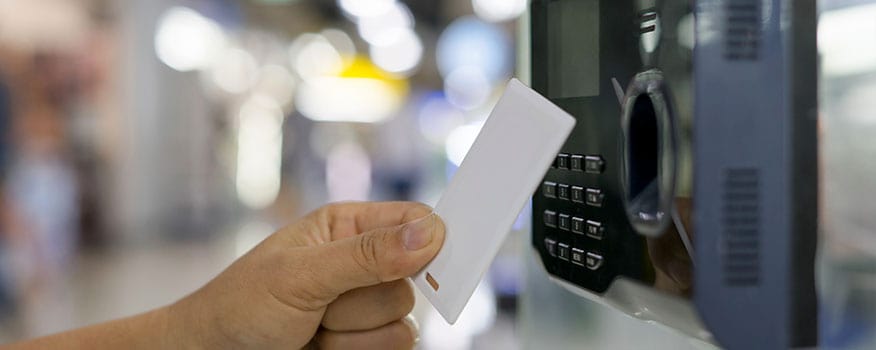 Person scanning their white card into a card reader door access control system