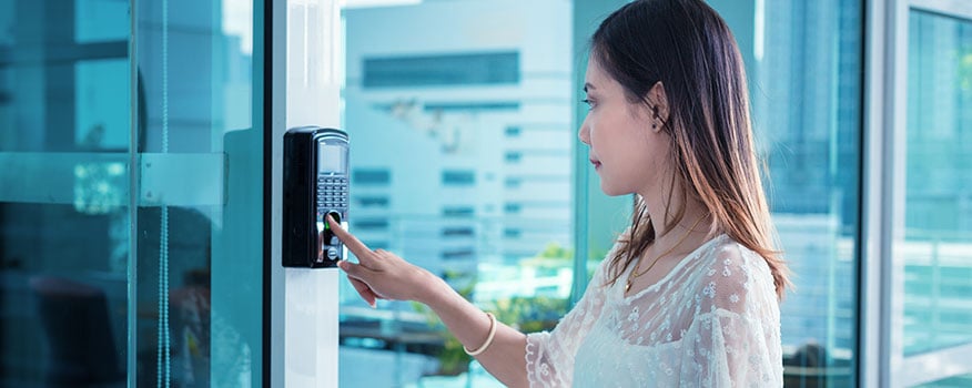 Woman using her hand to enter in a code on a commercial door access card in Tampa