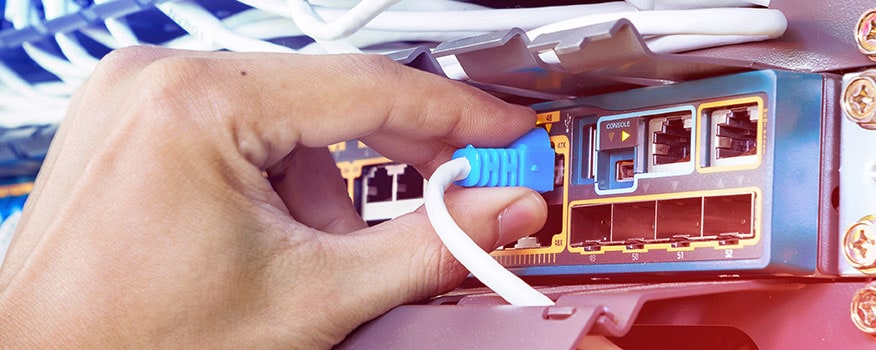 Man plugging ethernet cable into a switch for network cable installation